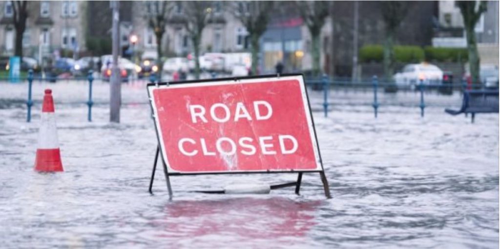 A road closure sign in a flooded road